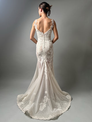 Back view of an elegant mermaid floral lace wedding dress with an open back and train, showcasing intricate lace details.
